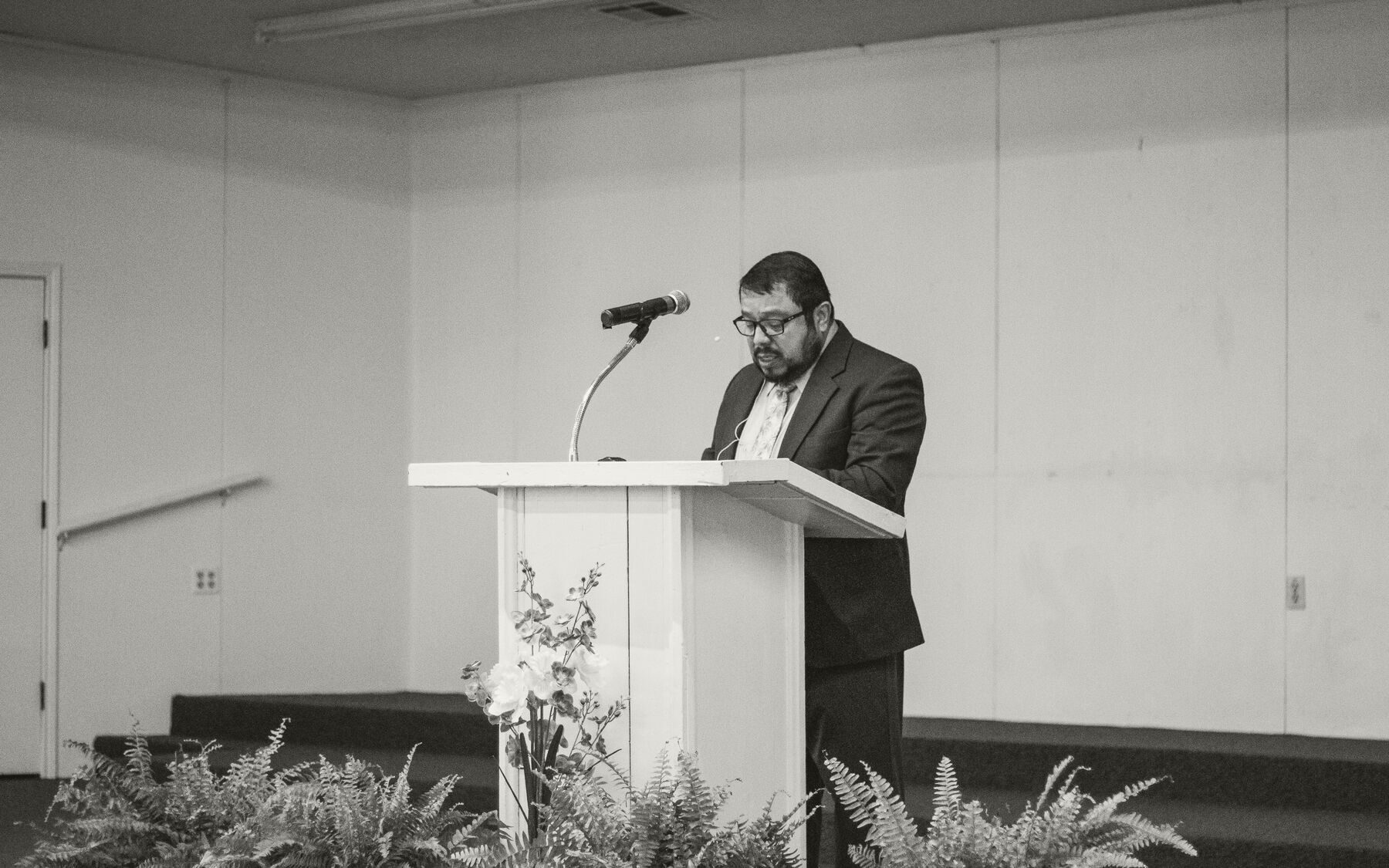A preacher speaking from a simple podium during one of the conference sessions.